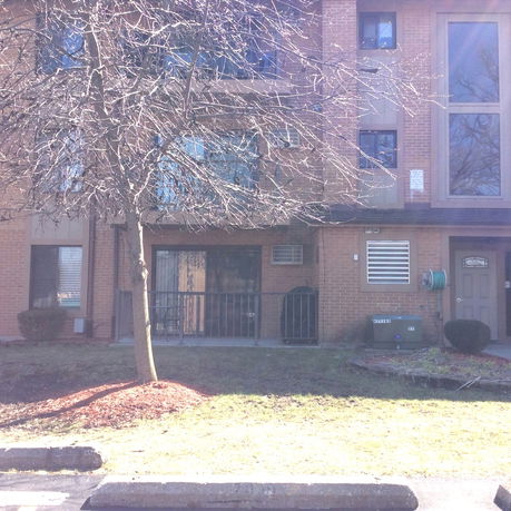 Front view of a multi-story brick building with balconies.