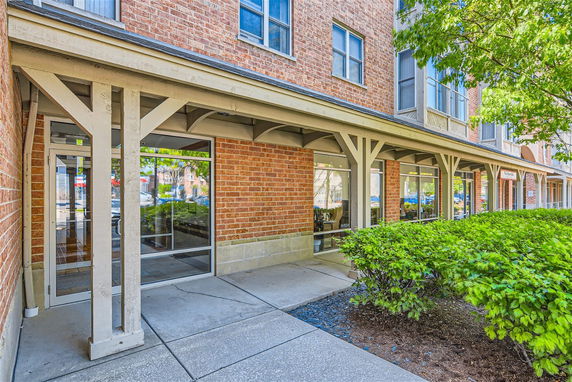 Front view of a multi-story brick building with large windows and a small walkway.