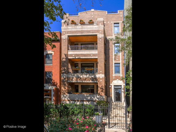 Front view of a multi-story brick building with balconies.