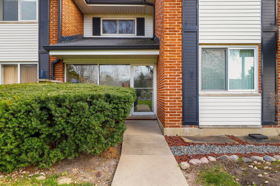 Front view of a house with a brick facade and a path leading to the entrance.