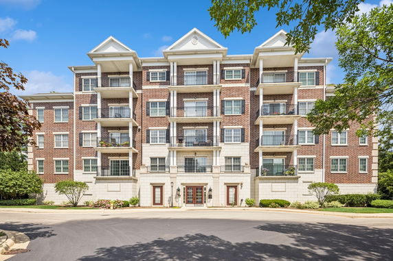 Front view of a multi-story apartment building with balconies.