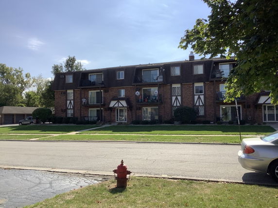 Front view of a multi-story residential building with balconies.