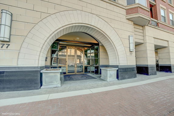 Front view of a building with an arched entrance and glass doors.