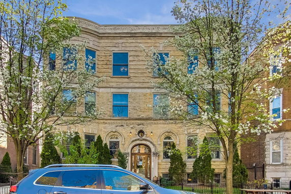 Front view of a multi-story brick building with arched windows.