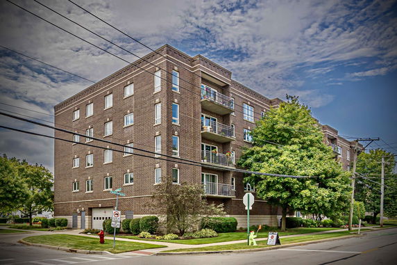 Front view of a multi-story brick building with balconies.