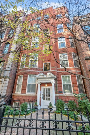 Front view of a multi-story brick building with large windows and a central entrance.