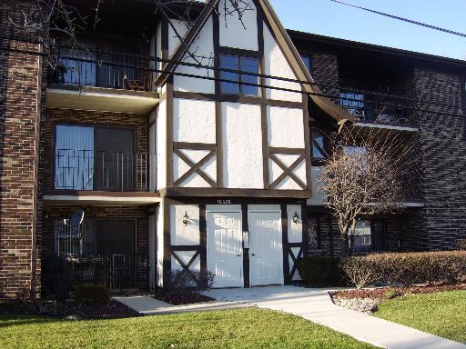 Front view of a multi-story residential building with a brick and timber facade.