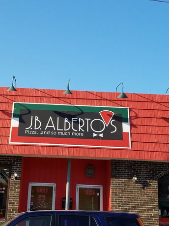 Front view of a building with a pizza restaurant sign.