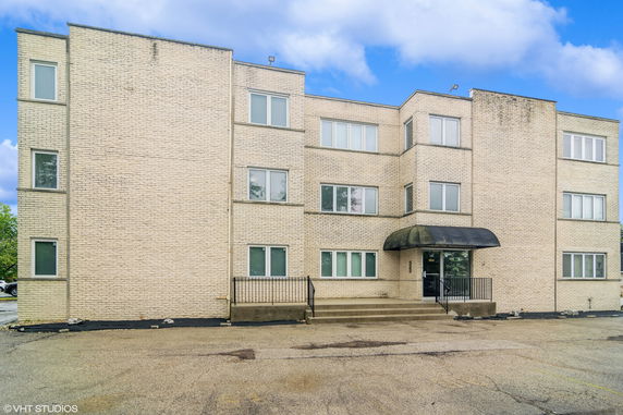 Front view of a three-story brick building with multiple windows and a central entrance.