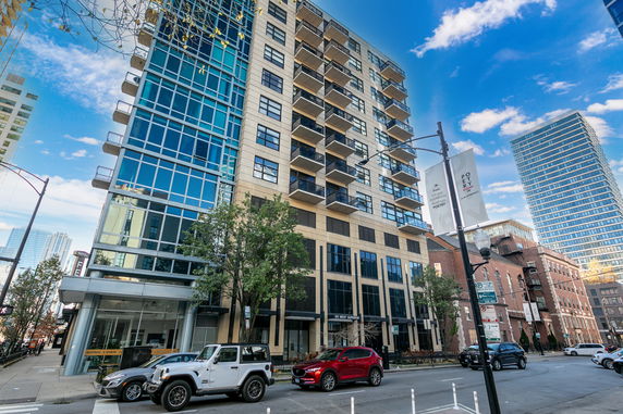 Front view of a multi-story building with balconies and large windows.
