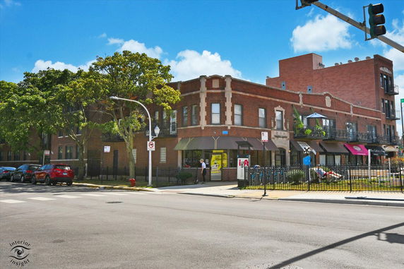 Front view of a two-story brick building with commercial spaces on the ground floor.
