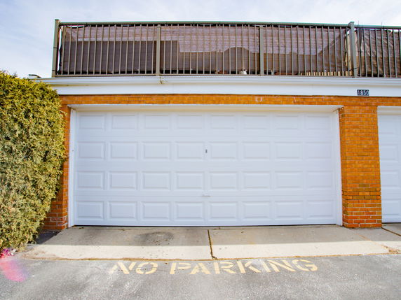Front view of a garage with a white door and brick exterior.