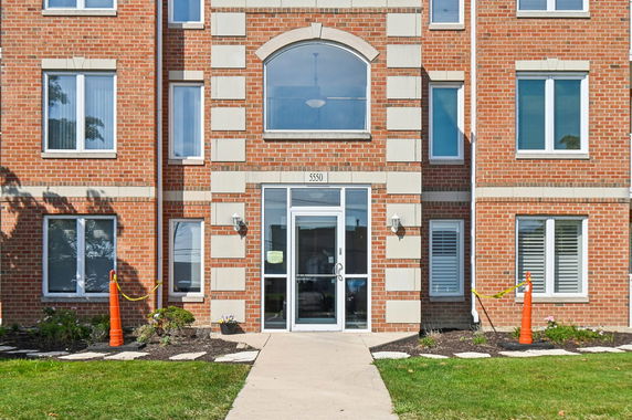 Front view of a multi-story brick building with large windows and a central entrance.