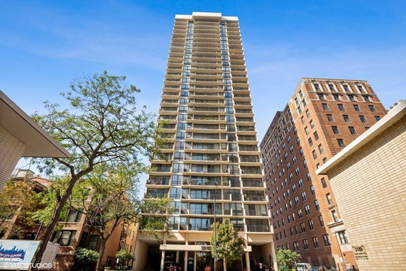 Front view of a tall apartment building with multiple balconies.