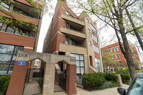 Front view of a multi-story building with a red and beige brick exterior.