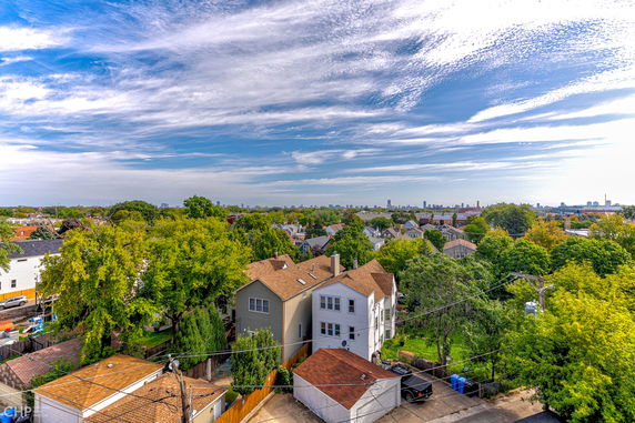 Panoramic view capturing a neighborhood with several houses and a distant skyline.