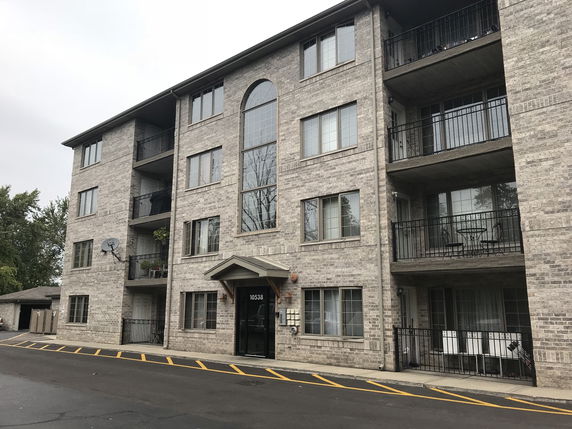 Front view of a multi-story apartment building with balconies.