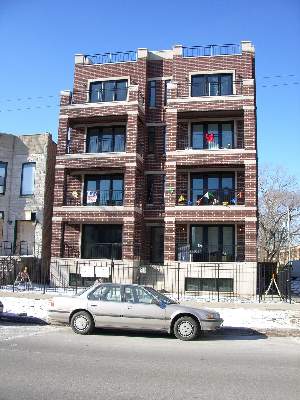 Front view of a multi-story brick apartment building.