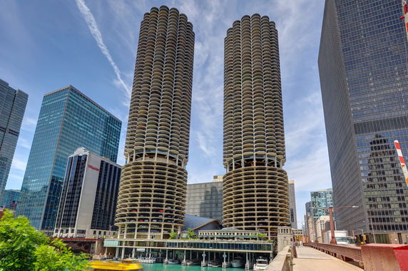 Front view of cylindrical twin towers with adjacent modern skyscrapers.