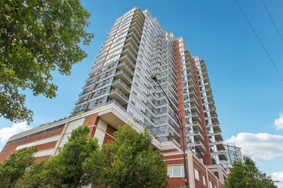 Front view of a high-rise residential building with multiple balconies.