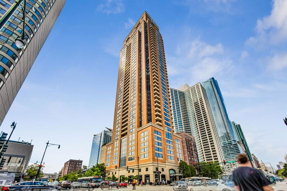 Front view of a high-rise building with a brown facade and numerous windows.