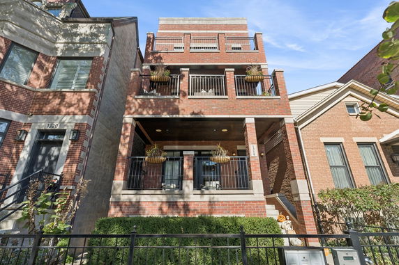 Front view of a multi-story brick building with balconies.