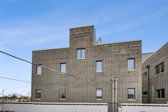 Front view of a multi-story building with a brick facade.
