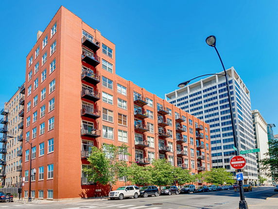 Front view of a multi-story brick building with balconies.
