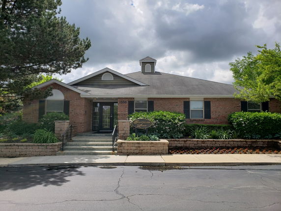 Front view of a single-story brick building with a gable roof and central entrance.