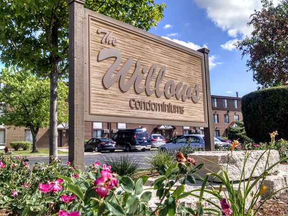 Front view of a condominium complex with a visible parking area.