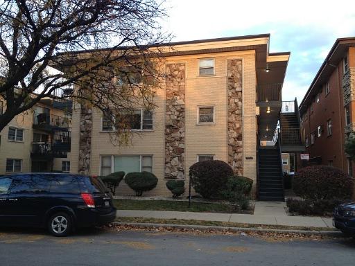 Front view of a three-story apartment building with external stairs.