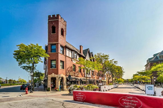 Front view of a multi-story brick building with a tower.