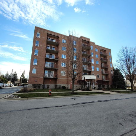 Front view of a multi-story brick apartment building.