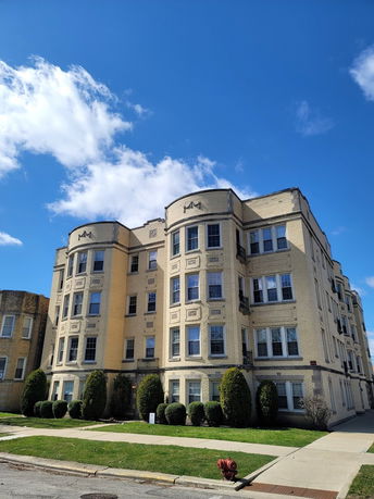 Front view of a multi-story residential building with bay windows.