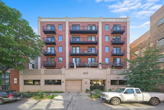 Front view of a multi-story apartment building with balconies.