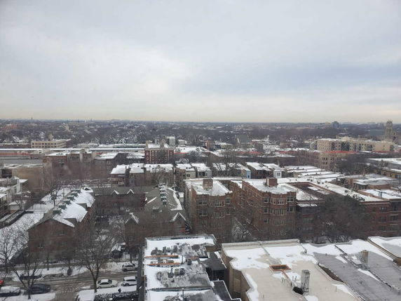 Panoramic view of a snow-covered urban area with numerous buildings.