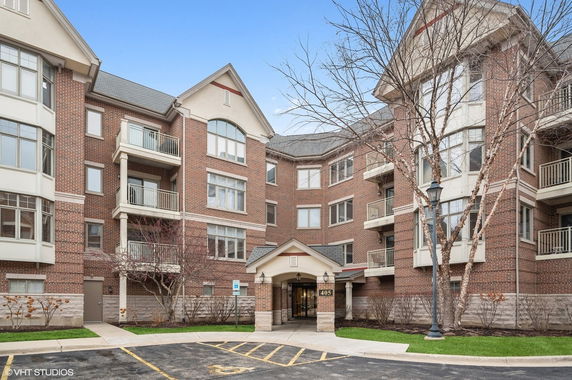 Front view of a multi-story apartment building with brick exterior and balconies.
