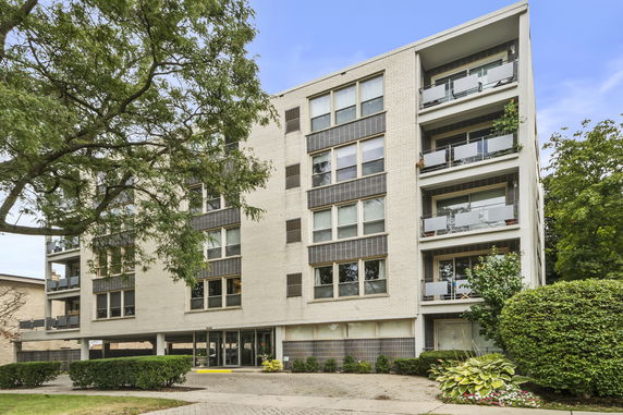 Front view of a multi-story apartment building with balconies.