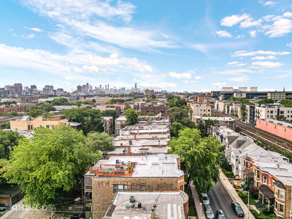 Wide angle view of a cityscape with buildings and trees, showcasing urban infrastructure.