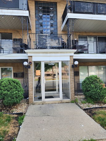 Front view of a multi-story building with balconies and a glass entrance.