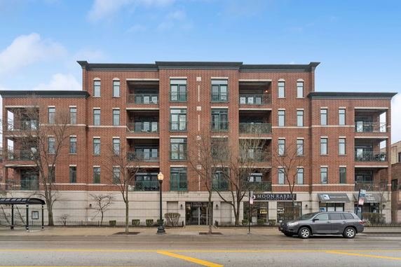 Front view of a multi-story brick building with balconies.