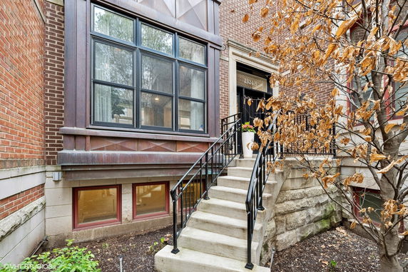 Front view of a brick house with a staircase leading to the entrance.
