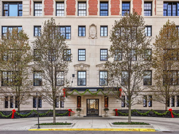Front view of a multi-story building with decorative wreaths and ribbons.