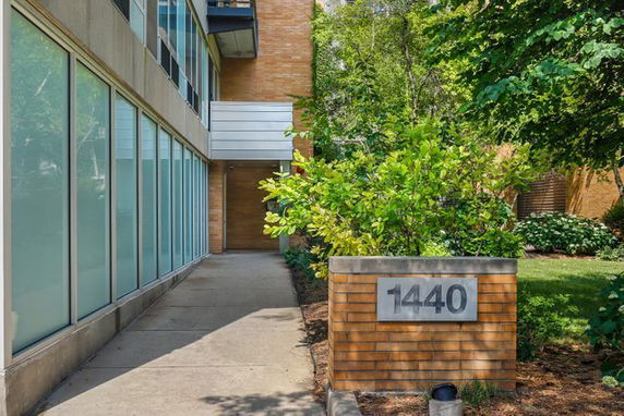 Entrance view of a building with a pathway and glass windows.