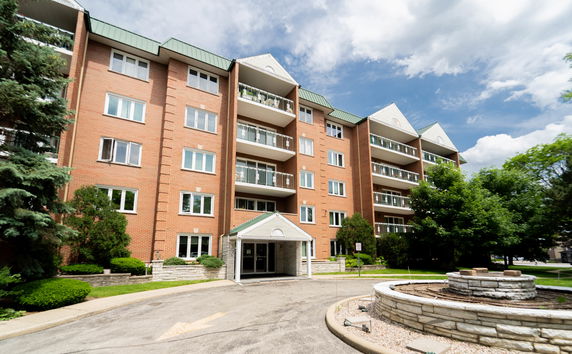 Front view of a multi-story apartment building with brick facade and balconies.