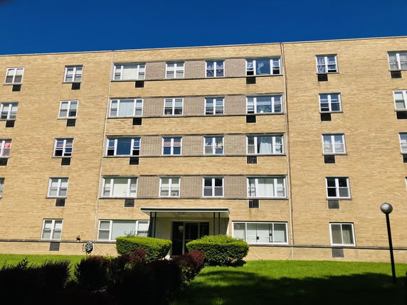 Front view of a multi-story residential building with a brick facade.
