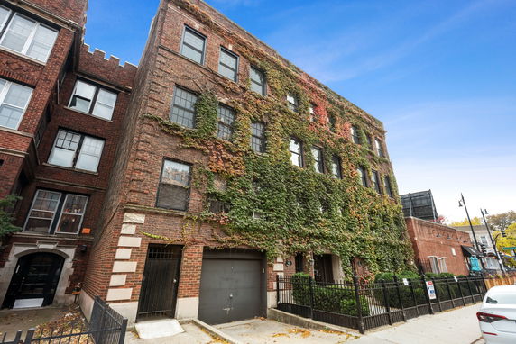 Front view of a multi-story brick building with ivy-covered facade.