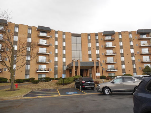 Front view of a multi-story residential building with balconies.
