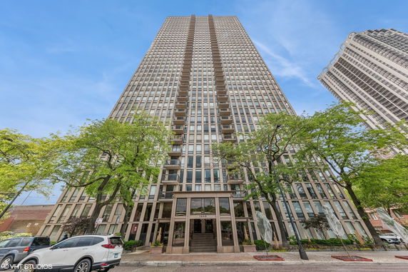 Front view of a tall multi-story building with numerous balconies.