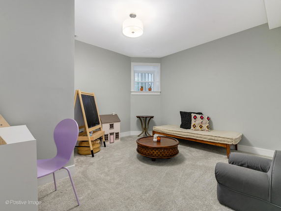 Indoor play area with chairs, a small table, a playhouse, and an easel